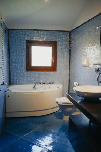 a bathroom with a tub and a toilet and a sink at Villa Alba Sul Mare in Budoni
