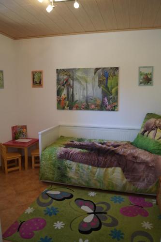 Hornburg的住宿－Das kleine Haus，卧室配有一张床,墙上挂有绘画作品