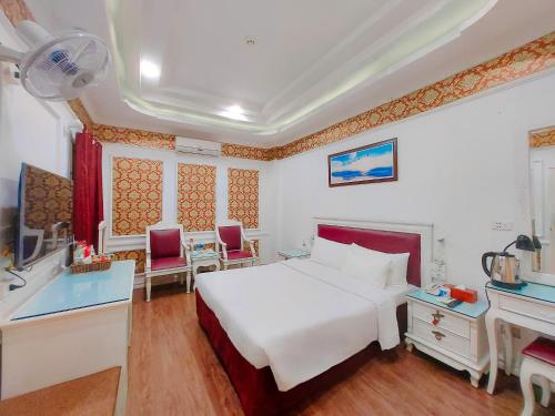 een hotelkamer met een wit bed en een badkamer bij A25 Hotel - Dịch Vọng Hậu in Hanoi
