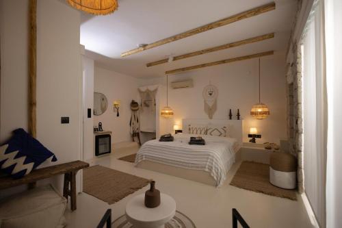 a white bedroom with a white bed and a table at ZOE ALAÇATI in Alacati