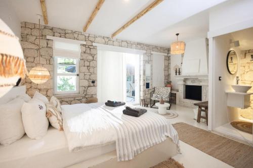 a bedroom with a white bed and a stone wall at ZOE ALAÇATI in Alacati
