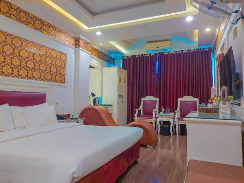 ein Schlafzimmer mit einem Bett und Stühlen in einem Zimmer in der Unterkunft A25 Hotel - Dịch Vọng Hậu in Hanoi