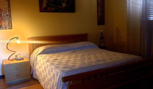 a bedroom with a bed and a lamp on a night stand at La Casita in Reggio di Calabria