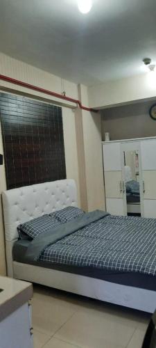1 dormitorio con 1 cama en una habitación con espejo en Puri Park View, en Yakarta