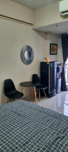Habitación con 2 sillas, mesa y nevera. en Puri Park View, en Yakarta