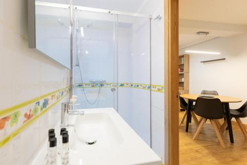 een badkamer met een douche, een wastafel en een tafel bij Euskalduna - baskeyrentals in Zarautz