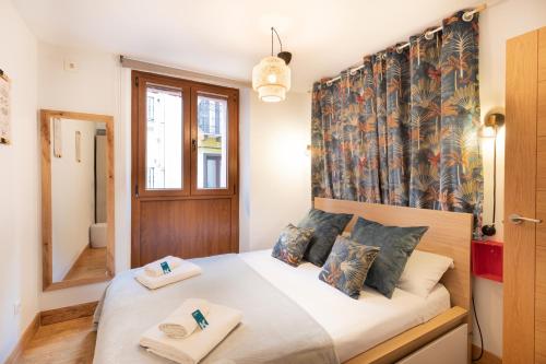 een slaapkamer met een bed en 2 handdoeken bij Euskalduna - baskeyrentals in Zarautz