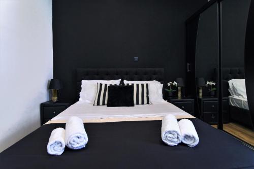アテネにあるNeo Luxury Suiteのベッドルーム1室(大型ベッド1台、タオル付)