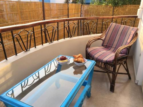 a balcony with a table and a chair on a balcony at Villa Elkoumy Apartments in Luxor