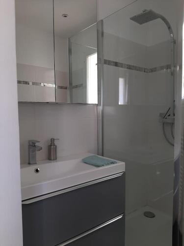 une salle de bain blanche avec un lavabo et une douche dans l'établissement Villa Agda, à Agde