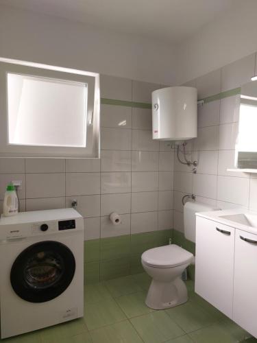 a bathroom with a washing machine and a toilet at Apartment Karlo, Pula in Pula
