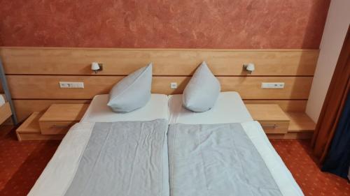 a bed with two pillows on it in a room at Terra Ventura Hotel in Gondorf