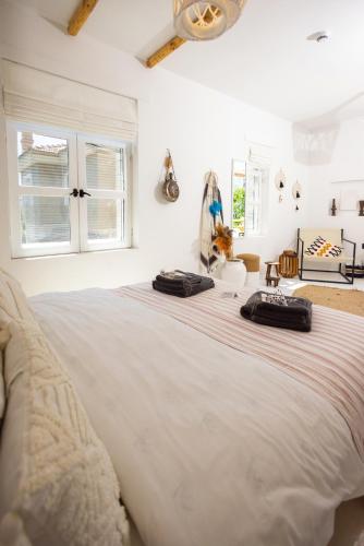 a bedroom with a large bed with two bags on it at ZOE ALAÇATI in Alacati