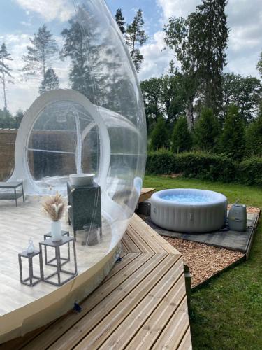 Tienda de burbujas en un patio con bañera de hidromasaje en La bulle du Bon'Heure en Somme-Leuze