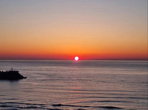 a sunset over the ocean with the sun setting at Yangyang Ocean Stay 환상적 전면 오션뷰 in Yangyang