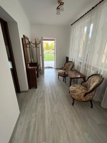 a living room with two chairs and a table at Charming individual house with a beautiful garden and self checkin in Satu Mare
