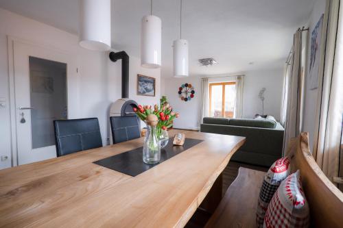 a dining room table with a vase of flowers on it at Ferienwohnung Falltannach in Sonthofen