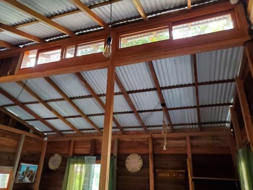 a room with a wooden ceiling with two windows at La posada de Mary in Montañita