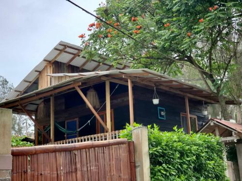 a house with a wooden fence in front of it at La posada de Mary in Montañita