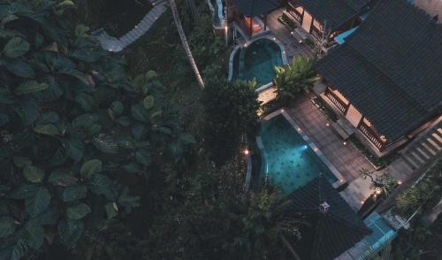 uma vista superior de uma piscina com árvores em Portobello Villa Ubud em Ubud