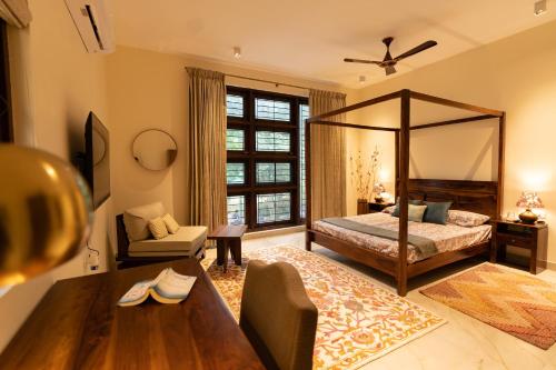 1 dormitorio con cama con dosel y sala de estar. en Luho 125, en Bangalore