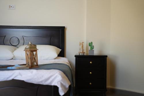 a bedroom with a black bed and a night stand at The Ranch in Kfar Hazîr