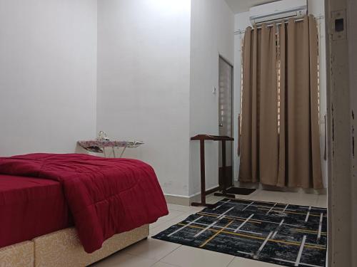 a bedroom with a red bed and a window and a rug at Afna Homestay 2 in Kuala Lipis