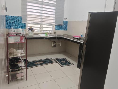 a kitchen with a counter and a refrigerator at Afna Homestay 2 in Kuala Lipis