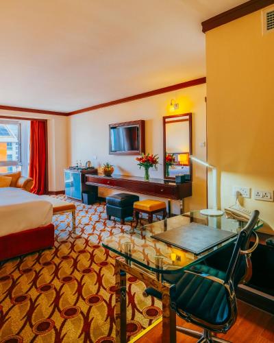 a hotel room with a bed and a desk at Mövenpick Hotel & Residences Nairobi in Nairobi