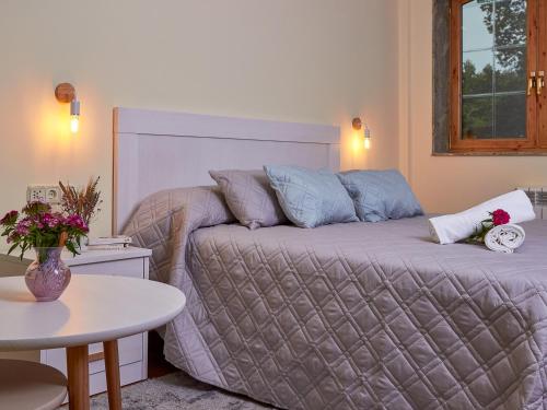 a bedroom with a bed and a table with a vase of flowers at Casa Río Samo in Garabanja