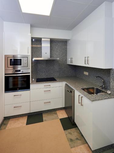 a kitchen with white cabinets and stainless steel appliances at Casa Río Samo in Garabanja