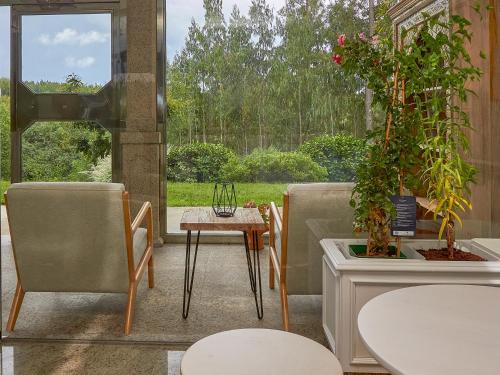a patio with two chairs and a table with a plant at Casa Río Samo in Garabanja