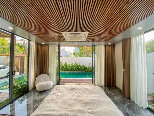 - une chambre avec un grand lit et une grande fenêtre dans l'établissement Song Cat Villa 59NL, à Đà Nẵng