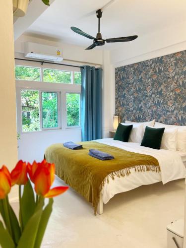 a bedroom with a large bed and a window at Cozy chic Silom townhouse studio 2-4 in Bangkok