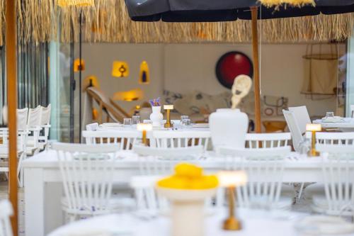 a dining room with white tables and white chairs at ZOE ALAÇATI in Alacati
