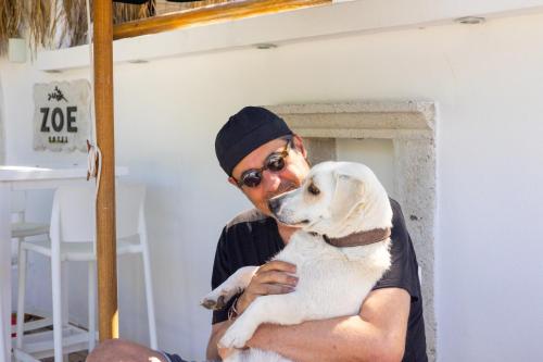 a man holding a white dog in his arms at ZOE ALAÇATI in Alacati