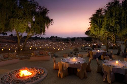 a dinner party in the desert at night with lights at The Ritz-Carlton Ras Al Khaimah, Al Wadi Desert in Ras al Khaimah
