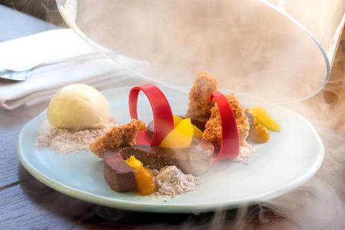 a white plate with food on a table at The Ritz-Carlton Ras Al Khaimah, Al Wadi Desert in Ras al Khaimah