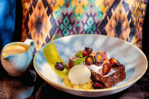 a plate of food with a dessert and a cup of coffee at The Ritz-Carlton Ras Al Khaimah, Al Wadi Desert in Ras al Khaimah