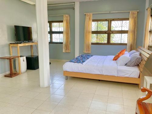 a bedroom with a bed and two windows and a tv at Private room in Central Pattaya Naeem House in Nong Prue