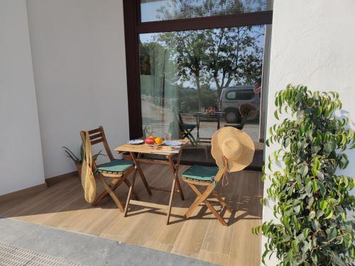 een patio met een tafel en stoelen en een raam bij Mi Casita De Garraf in Garraf