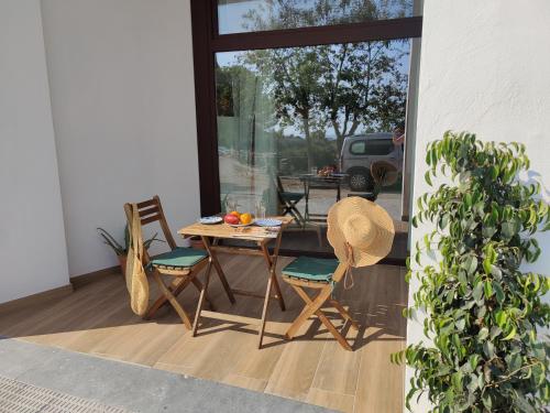 a patio with a table and chairs and a window at Mi Casita De Garraf in Garraf