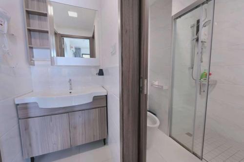 ein weißes Bad mit einem Waschbecken und einer Dusche in der Unterkunft 16 Forest City homestay-free WIFI-森林城市民宿 in Johor Bahru