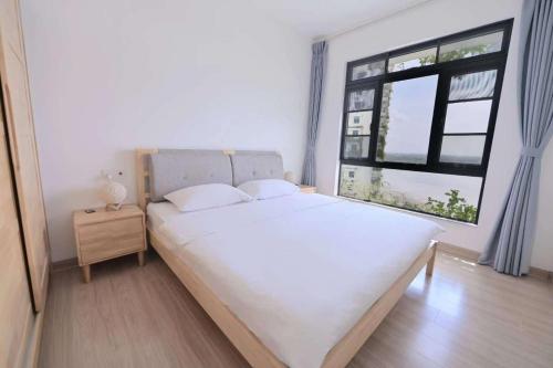 um quarto com uma grande cama branca e uma janela em 16 Forest City homestay-free WIFI-森林城市民宿 em Johor Bahru