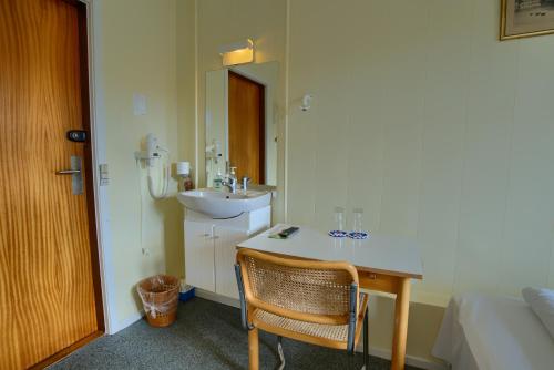 a bathroom with a sink and a desk with a sink at Ebsens Hotel in Maribo