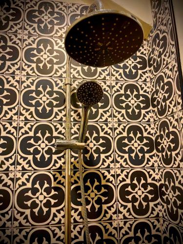 La salle de bains est pourvue d'un mur avec du carrelage noir et blanc. dans l'établissement Appartement élégant - 2 chambres - 2 salles de bain, à Paris