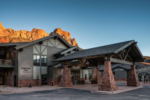 a building with a mountain in the background at SpringHill Suites by Marriott Springdale Zion National Park in Springdale