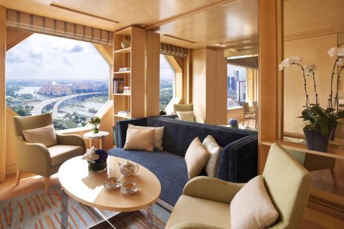a living room with a blue couch and a table at The Ritz-Carlton, Millenia Singapore in Singapore