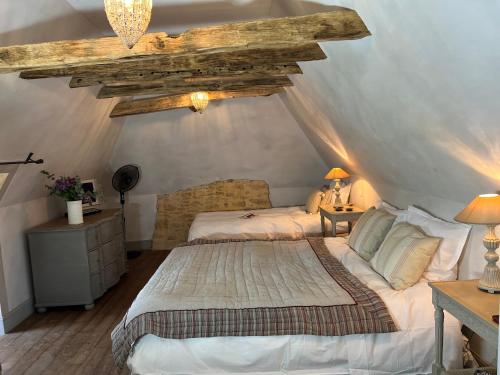 - une chambre mansardée avec un grand lit dans l'établissement Les Maisons d'Antan 5 étoiles, à Saint-Geniès