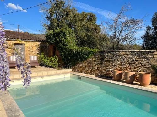 einen Pool vor einer Backsteinmauer in der Unterkunft Les Maisons d'Antan 5 étoiles in Saint-Geniès